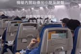 Passengers hold oxygen masks to their faces after their plane dropped 26,900ft.