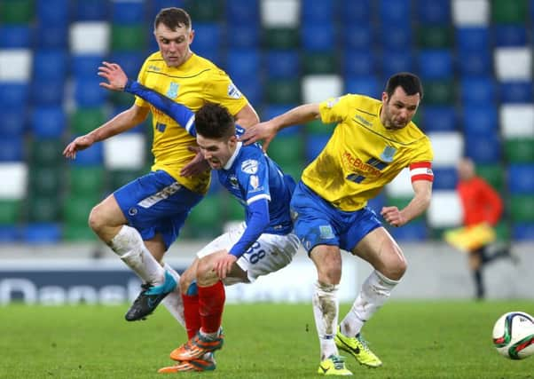 Paul Smyth feels the full force of this challenge during a recent Irish Cup game with Ballymena United