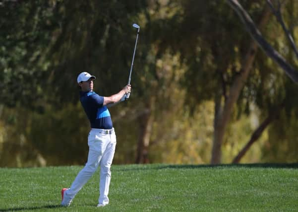 Rory McIlroy follows his ball on the 18th hole